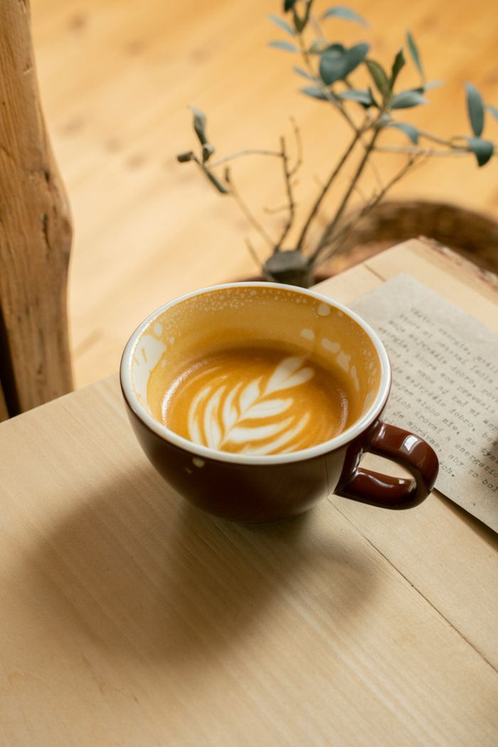 why-choose-us Warm, inviting cafe setting with latte art coffee in Sabinov. Perfect for coffee enthusiasts.